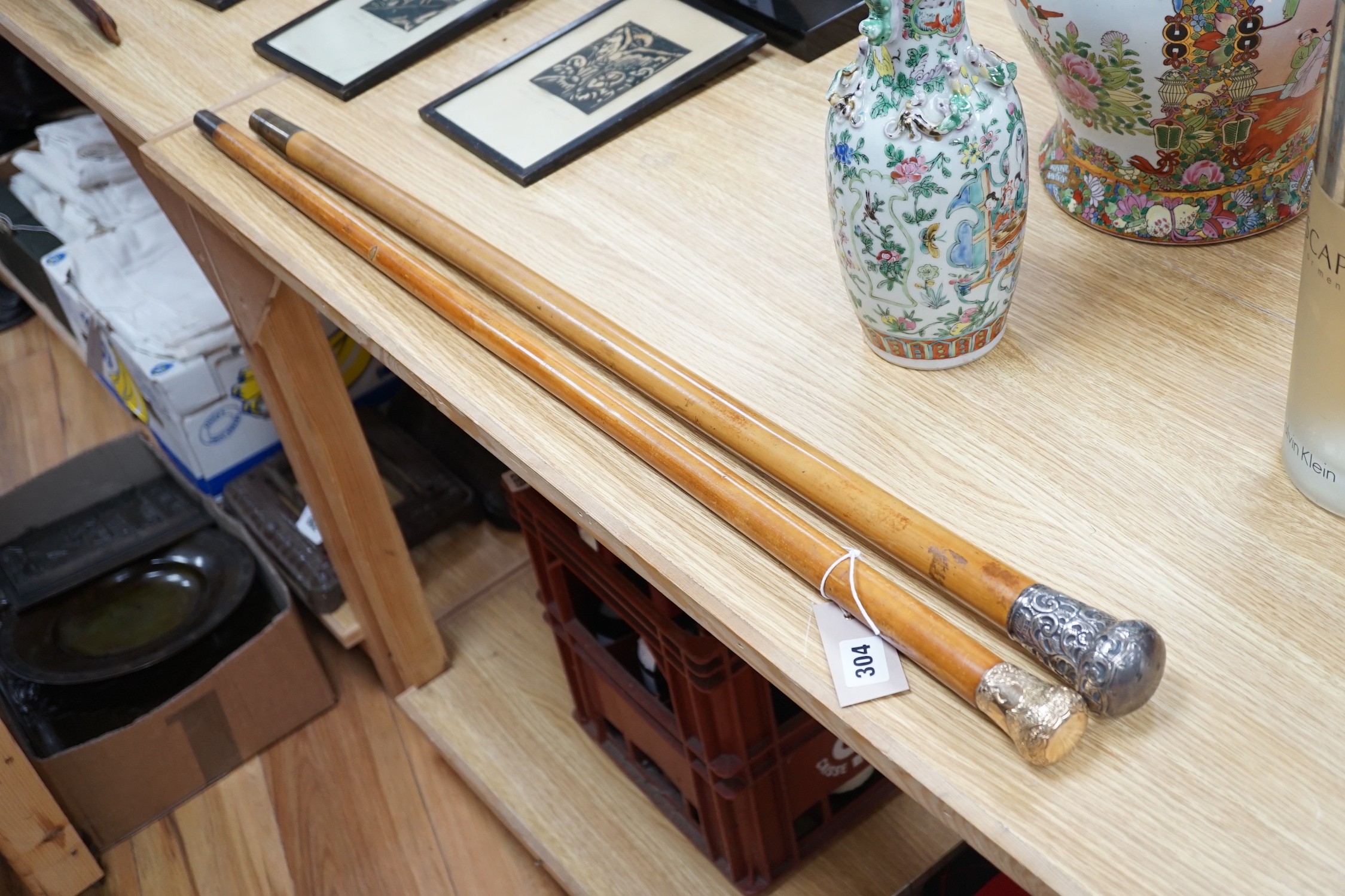 Two 19th century malacca walking canes: one with an Indian inspired 9ct gold handle, the other with a silver embossed handle, gold handled cane 92 cms long